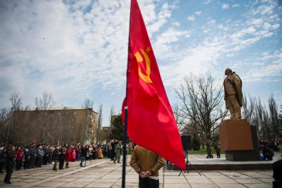 A Soviet Union flag flutters as people attend the unveiling of a Lenin statue in the town of Novoazo